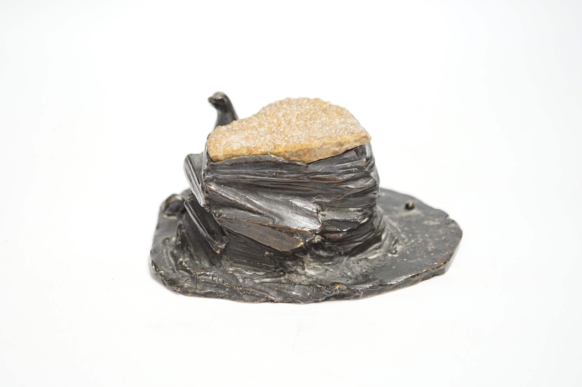 A bronze desk weight, a seal on rock, quartz mounted, 15cm wide